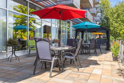 Patio tables and umbrellas beside the residence windows