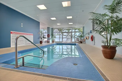 Indoor pool with entry steps, a ladder and potted plants