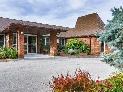 Brick building with a covered entrance and landscaped plants