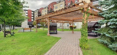 Garden path beneath a wooden pergola beside outdoor seating