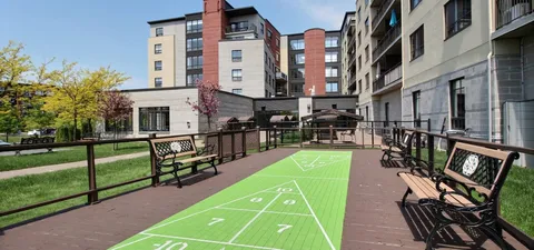 Outdoor shuffleboard court between benches beside the residence
