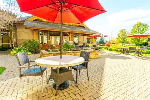 Patio with metal tables, chairs and surrounding trees