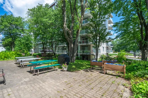 Patio with picnic tables and raised garden beds beside the residence.