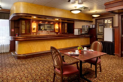 Pub counter and seating beneath curved wooden cabinetry