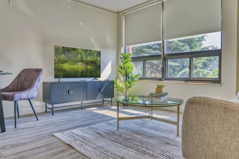 Suite sitting area beside large windows and a television