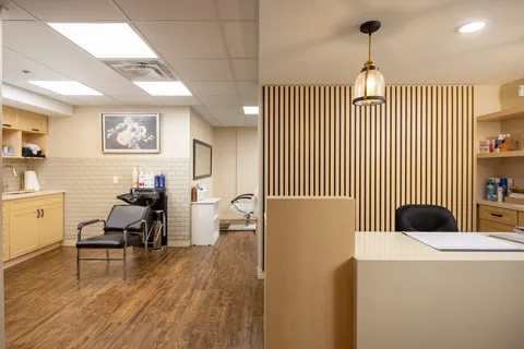 Salon with styling chairs, sinks and wooden flooring