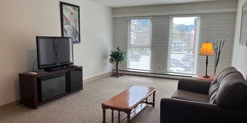 Sitting area with sofa, coffee table, television and patio doors