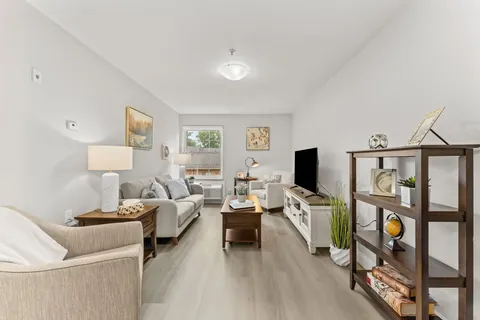 Sitting area with armchairs, a sofa, television and shelving