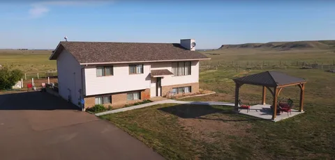 Two-storey house beside a lawn and an open gazebo