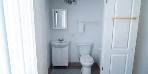 Bathroom with a washbasin, mirror, toilet and towel rail