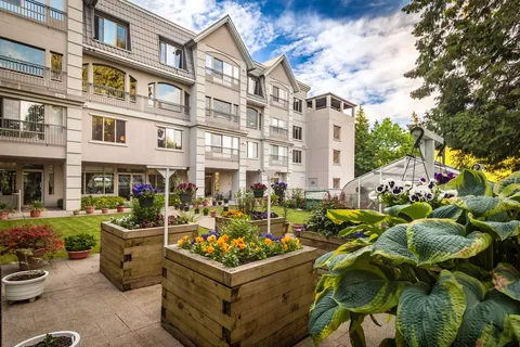 Residence behind gardens, trees and a paved walkway