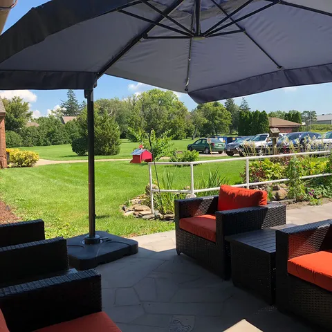 Patio with an umbrella, table, outdoor armchairs and flower planters