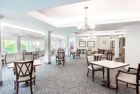 Dining room with tables, chairs, chandeliers and large windows