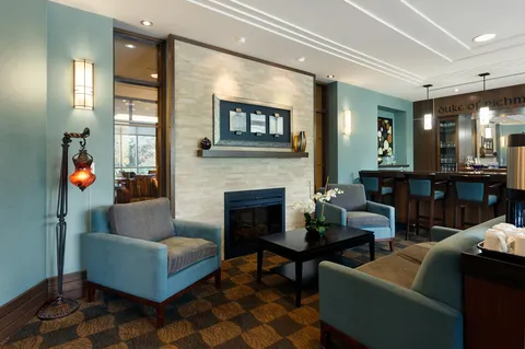 Pub lounge with armchairs beside a fireplace.