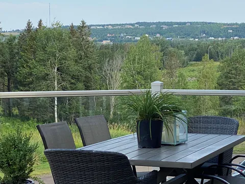 Patio table and chairs overlooking a wooded hillside