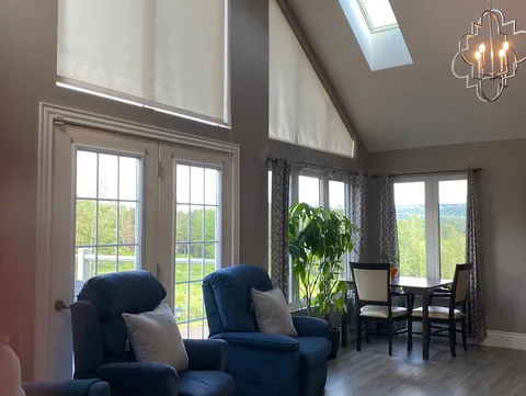 Blue recliners and a dining table beneath tall windows