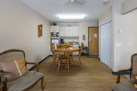 Suite kitchen and dining area with wooden table and cabinets.