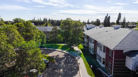 Aerial view of the residence beside trees and a paved drive.