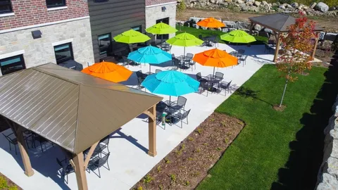 Aerial view of a courtyard with tables, umbrellas, a gazebo and lawn