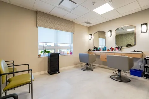 Hair salon with styling chairs, mirrors, counters and a window