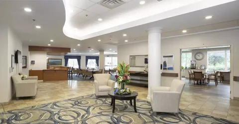 Open seating area with cream armchairs, tables and a reception counter