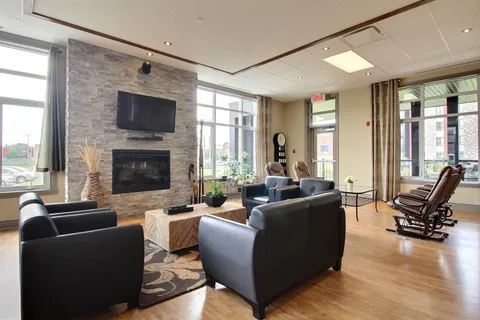 Common lounge with leather seating, a fireplace and television.
