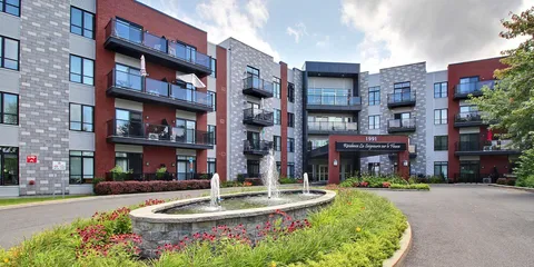 Residence buildings around a fountain and entrance driveway.