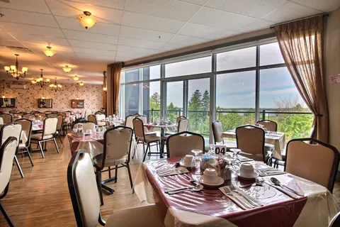 Dining room with set tables and windows overlooking the river.