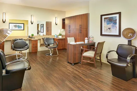 Salon with styling chairs, hair dryers, wood cabinets and wall mirrors