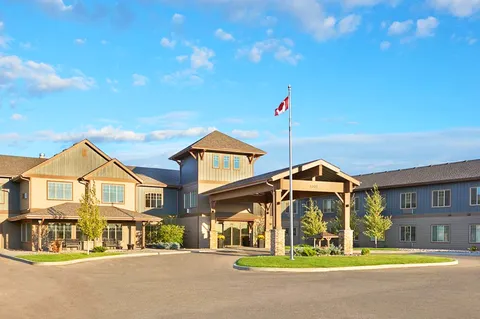 Residence exterior with a covered driveway, landscaped island and Canadian flag