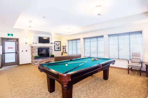 Games room with a billiards table, stone fireplace and large windows