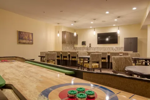 Games room with a shuffleboard table and counter seating