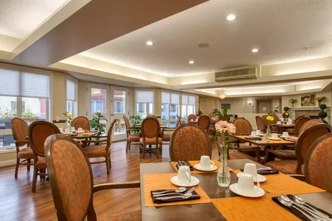 Dining room with set tables, upholstered chairs and large windows