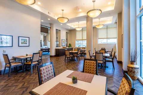 Tables and chairs in a bright room with tall windows