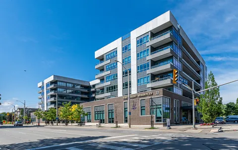 Glass and brick residence with balconies beside a street intersection