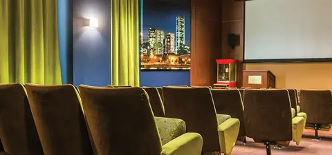 Cinema room with rows of seats and a blank screen