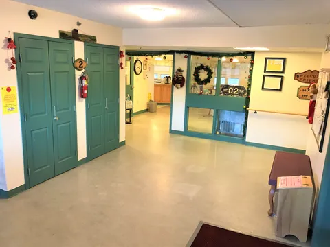 Interior corridor with green doors and an opening into the dining room.