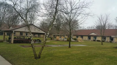 Residence overlooking a lawn with trees and a gazebo