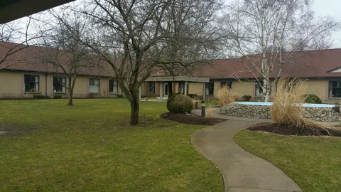 Single-storey residence beside a lawn, trees and a curved path