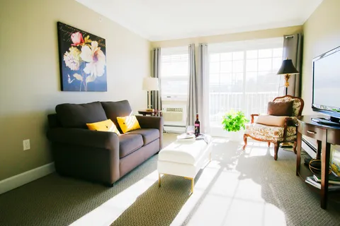 Sitting area with a sofa, armchair and television beside glass doors