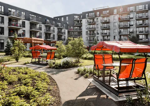 Garden paths and orange covered swings in a courtyard surrounded by balconies