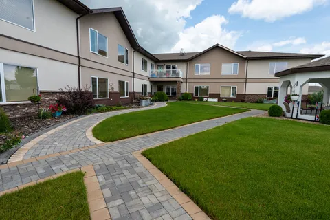 Residence courtyard with a paved walkway and lawn.