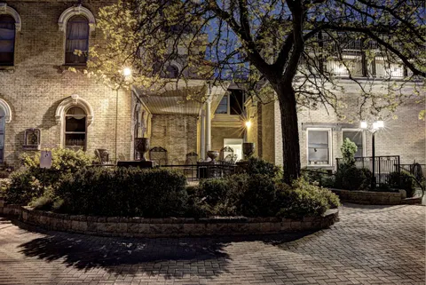 Illuminated brick building and covered porch at night