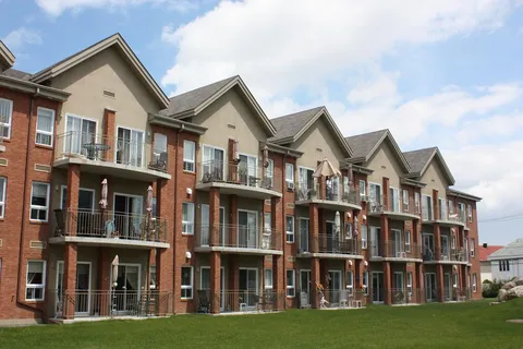 Brick residence with rows of balconies beside a lawn