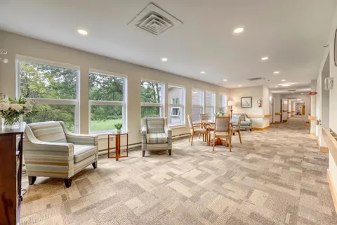 Room with striped armchairs beside a wall of windows