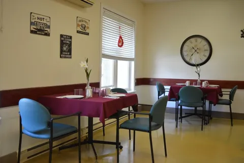 Dining tables with red tablecloths and blue chairs