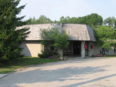 Residence entrance beneath a wide shingled roof