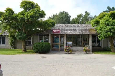Single-storey residence with trees, shrubs and an entrance driveway