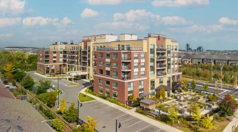 Aerial view of a multi-storey brick residence with balconies, a driveway and courtyard gardens