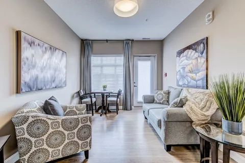 Suite living area with a sofa, armchairs and a window.